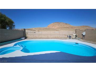 Backyard in ground pool with blue water and surrounding desert landscape offers a tranquil outdoor retreat at 83 Rock Run St, Las Vegas, NV 89148