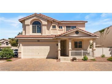 Charming two-story home featuring a red tile roof, a two-car garage, and a cozy front porch at 10276 Cherry Brook St, Las Vegas, NV 89183