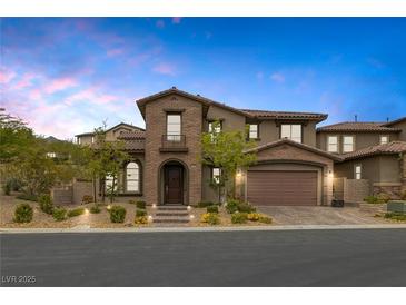 Charming two-story home featuring brick and stucco, manicured landscaping, and a two-car garage at 11944 Dolcemente Ln, Las Vegas, NV 89138