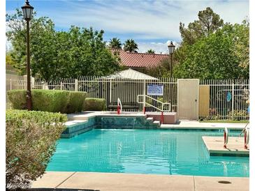 Community pool with clear blue water and adjacent lounge area, perfect for relaxation and recreation at 1753 Tanner Cir, Henderson, NV 89012