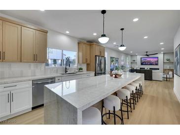 Modern kitchen with stainless steel appliances, marble countertops, and a large island with seating at 193 Jeri Dr, Henderson, NV 89074