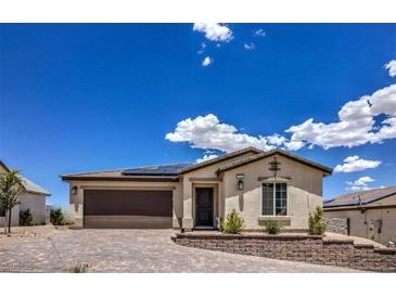 Inviting single-story home featuring a two-car garage, desert landscaping, and charming curb appeal at 314 W Winston Ln, Indian Springs, NV 89018