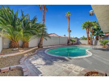 Backyard pool surrounded by palm trees and well-maintained landscaping at 3791 El Camino Rd, Las Vegas, NV 89103
