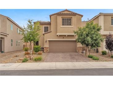 Two-story home featuring a well-manicured lawn, a brick driveway, and a 2-car garage at 5731 Sedona Springs St, North Las Vegas, NV 89031