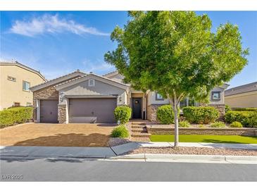 Charming single-story home featuring a three-car garage and professionally landscaped front yard with mature trees at 7340 Orchard Harvest Ave, Las Vegas, NV 89131