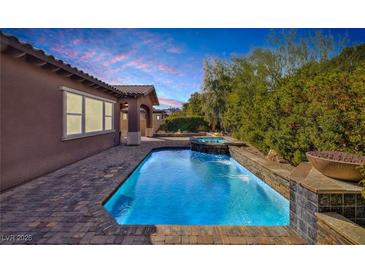 Sparkling pool and spa with mature landscaping and a beautiful sunset view at 775 Porto Mio Way, Las Vegas, NV 89138