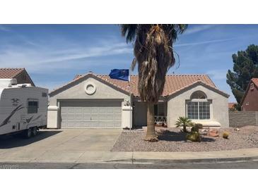 Charming single-story home features a xeriscaped front yard, a two-car garage, and an RV parked to the side at 812 Rio Poco Ct, Henderson, NV 89015