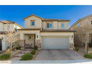 Charming two-story home with a two-car garage and meticulously paved driveway enhanced by stone accents and manicured landscaping at 9953 Fletcher Peak Ave, Las Vegas, NV 89178