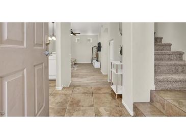 Inviting entryway featuring tile flooring, stairs, and an open floor plan leading to the living area at 10324 Lettuce Leaf St, Las Vegas, NV 89183