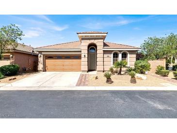 Charming single-story home featuring a well-manicured front yard, desert landscaping, and an attached two-car garage at 10385 Kern Ridge St, Las Vegas, NV 89178