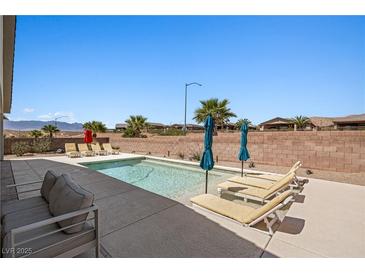 Inviting backyard pool featuring lounge chairs and umbrellas for a relaxing outdoor experience at 1357 Manassas Rdg Rdg, Mesquite, NV 89027