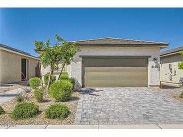 Inviting single-story home with a two-car garage, xeriscaped front yard, and stone driveway at 2110 Albury Ave, North Las Vegas, NV 89086