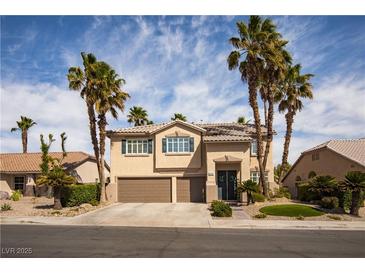 Two-story home boasts a two-car garage, desert landscaping, and tall palm trees at 2544 Sundew Ave, Henderson, NV 89052