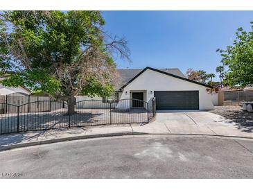 Charming single-story home featuring a gated front yard, desert landscaping and a spacious driveway leading to a two-car garage at 2671 Diamante Cir, Las Vegas, NV 89121