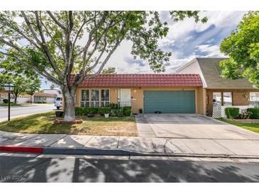 Charming single-story home featuring a red tile roof and lush landscaping in a tranquil neighborhood at 3879 Atlantis St, Las Vegas, NV 89121