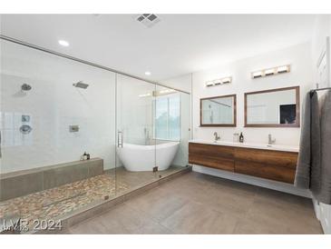 Modern bathroom featuring a walk-in shower, soaking tub, double vanity, and sleek, contemporary fixtures at 3934 Sangre De Cristo Ave, Las Vegas, NV 89118