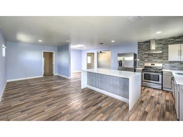 Modern kitchen boasts stainless steel appliances, a large island, and hardwood floors, creating a perfect culinary space at 417 Wisteria Ave, Las Vegas, NV 89107