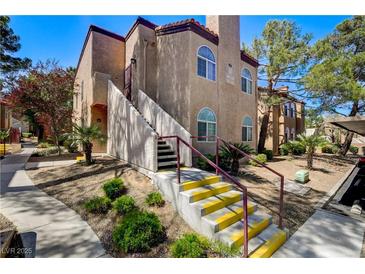 Inviting two-story condo with well-maintained landscaping and stairs leading to the front entrance at 9325 W Desert Inn Rd # 143, Las Vegas, NV 89117