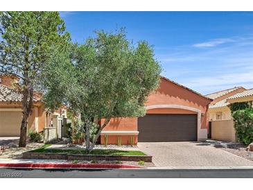 Charming home with a two-car garage, tree in the front, and a well-manicured lawn in a lovely community at 12 Via Ravello, Henderson, NV 89011
