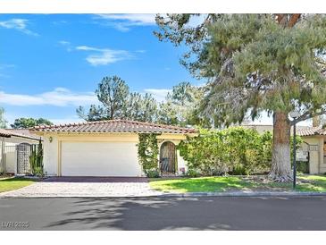 Charming single-story home featuring a red tile roof, a two-car garage, and a well-manicured front yard at 1901 Calle De Espana, Las Vegas, NV 89102