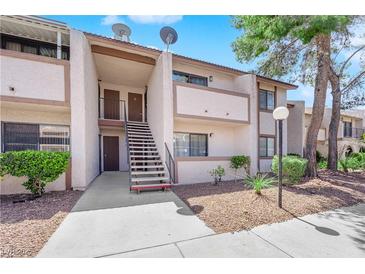 Inviting condo exterior features stairs to the second floor, neutral color palette and desert landscaping at 5241 Janfred Ct # 26, Las Vegas, NV 89103