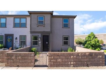 Charming two-story townhouse with neutral exterior and a quaint front yard featuring a low brick wall at 756 Sleeping City Ave, Henderson, NV 89015