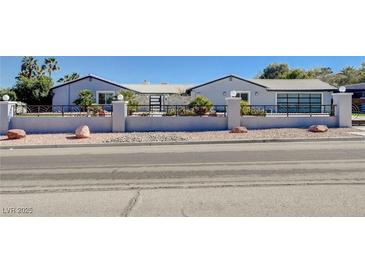 Charming single-story home featuring a decorative metal gate and desert landscaping for curb appeal at 7575 Coley Ave, Las Vegas, NV 89117