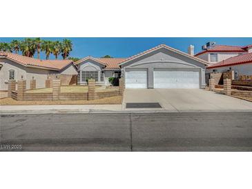 Charming single-story home with a two-car garage, desert landscaping, and a tile roof at 7898 Rye Canyon Dr, Las Vegas, NV 89123