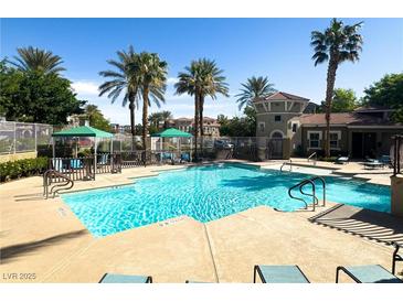 Inviting community pool with lounge chairs and palm trees offers a relaxing outdoor retreat at 10001 Peace Way # 2228, Las Vegas, NV 89147