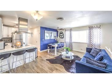 Open living space with modern kitchen, dining area, and cozy blue sofa at 1508 Dorothy Ave # 4, Las Vegas, NV 89119