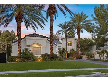 Charming single-story home with palm trees, lush landscaping, and a well-manicured lawn at 2337 Prometheus Ct, Henderson, NV 89074