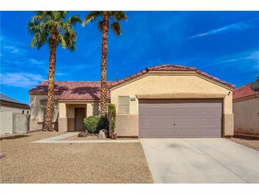 Charming single-story home with a desert landscape, tile roof, and a two-car garage at 6128 Casper Sands Ct, North Las Vegas, NV 89031