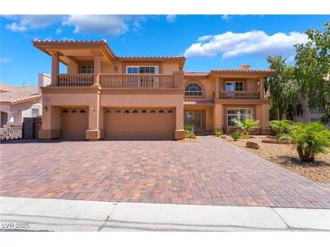 Stunning two-story home featuring a brick driveway, balconies, and a three-car garage at 7526 Gossamer Wind St, Las Vegas, NV 89139