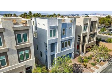 Modern three-story home with blue and grey accents and a rooftop deck offers contemporary living at 8016 Carpenter Creek Ave, Las Vegas, NV 89113
