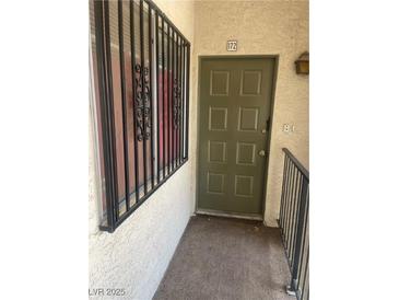 A welcoming olive-green front door with security bars on the adjacent window invites you into your new home at , Las Vegas, NV 89115