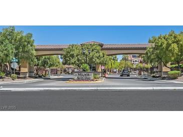 Stone entrance to the Village Avellino community with trees and a decorative tile covered roof at 1121 Via Castelli, Henderson, NV 89052
