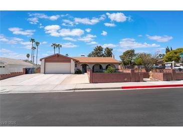 Charming single-story home with a well-maintained lawn, and palm trees, perfect curb appeal at 1534 Irene Dr, Boulder City, NV 89005