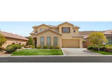 Charming two-story stucco home with a well-manicured front lawn, mature landscaping, and a two-car garage at 17 Morninglow Pass, Henderson, NV 89052