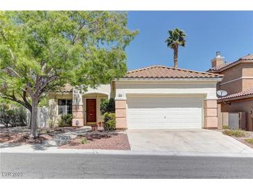 Charming single-story home with a two-car garage, desert landscaping and mature shade tree in the front yard at 1945 Trail Peak Ln, Las Vegas, NV 89134