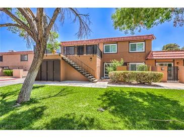 Well-maintained two-story townhouse with manicured landscaping, staircase, and charming red tile roof at 250 Shadybrook Ln # D, Las Vegas, NV 89107