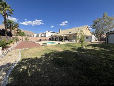 Expansive backyard with a sparkling pool, mature landscaping, and covered patio, perfect for outdoor entertaining at 6596 Secluded Ave, Las Vegas, NV 89110