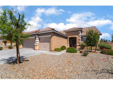 Charming single-story home with a three-car garage and well-maintained desert landscaping in front yard at 7559 Chambery Cove Ct, Las Vegas, NV 89123