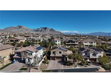 An aerial view of a suburban neighborhood showcases lovely homes against the backdrop of beautiful mountains at 12124 Kite Hill Ln, Las Vegas, NV 89138