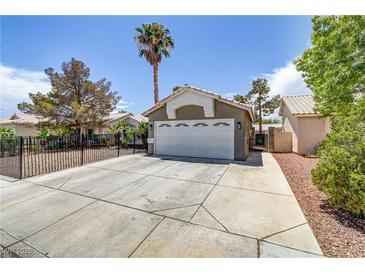 Front exterior features a two-car garage, low maintenance yard, and a desert landscape at 5045 Sock Hop Way, North Las Vegas, NV 89031