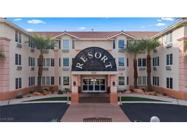 Inviting resort entrance with palm trees, well-manicured landscaping and ample parking at 555 Highland Dr # 203, Mesquite, NV 89027