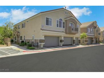 Attractive two-story condo with attached garage and neutral stucco exterior at 5553 High Wager Way # 101, Las Vegas, NV 89122