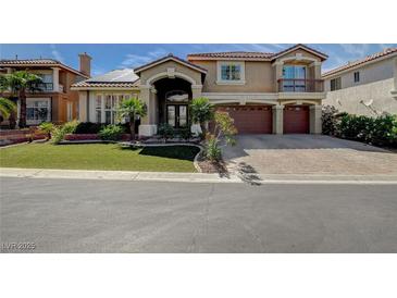 Charming two-story home featuring a red tile roof, desert landscaping, and a three-car garage at 7619 Belgian Lion St, Las Vegas, NV 89139