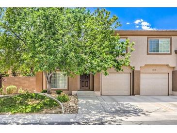 Charming townhouse with a well-manicured lawn, a mature shade tree, and a two-car garage at 1605 Colloquium Dr, Henderson, NV 89014