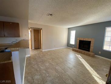 Open-concept living room featuring tile floors and a cozy fireplace at 2685 Bryandouglas Dr, Las Vegas, NV 89121