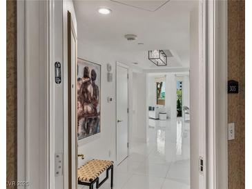 Bright hallway featuring white tile floors, modern lighting, and elegant artwork, leading to a comfortable living space at 2857 Paradise Rd # 305, Las Vegas, NV 89109